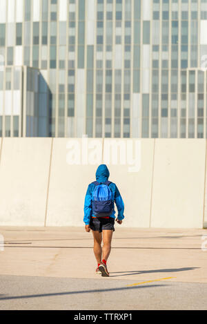 Vue arrière des hauts hoodie sport homme portant un sac à dos et marche loin Banque D'Images