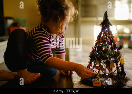 Un enfant aux pieds nus explore un jouet de belle lumière Banque D'Images