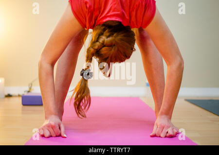 Une femme pratique le yoga sur un tapis de yoga Banque D'Images