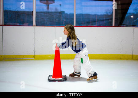 Une petite fille dans des pantalons de neige et glace Patins Patins seul dans une patinoire Banque D'Images