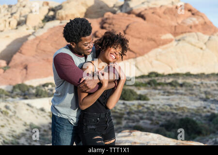 Romantic couple standing rock formation Banque D'Images