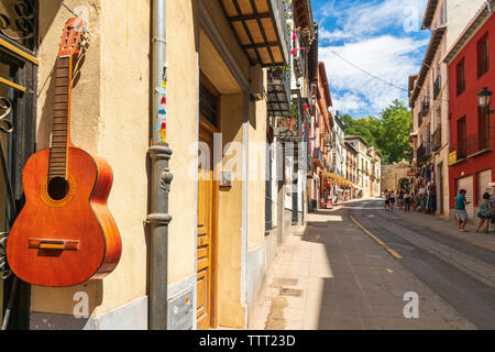 Guitare classique accroché sur le mur de maison traditionnelle dans la région de la Cuesta de Gomerez street, Grenade, Andalousie, Espagne Banque D'Images