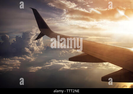 Portrait de l'avion volant au-dessus de ciel nuageux Banque D'Images