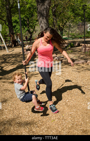 Toute la longueur du tirant mère zip line avec fils tout en jouant au jeu pour enfants Banque D'Images