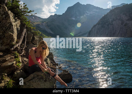 Woman by lake in forest Banque D'Images