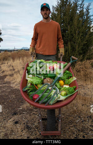 Portrait d'un homme transportant des fruits et légumes dans une brouette Banque D'Images