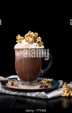 Close-up de chocolat chaud avec de la crème fouettée et maïs soufflé au caramel Banque D'Images