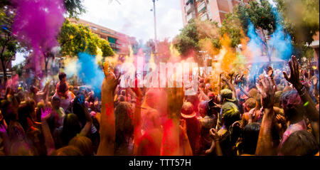 Les gens célébrant Holi festival on city street Banque D'Images