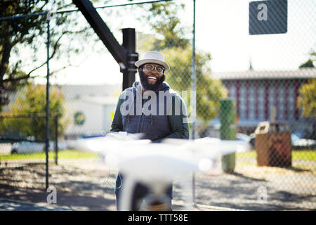 Cheerful man flying drone en basket-ball Banque D'Images