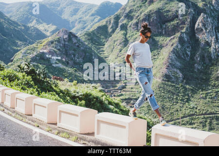 Vue avant du femme marche par la route au milieu des montagnes Banque D'Images