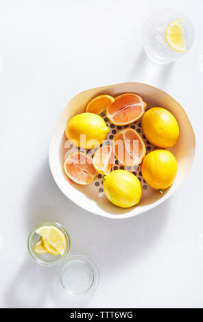 Close-up de citrons dans le récipient sur fond blanc Banque D'Images