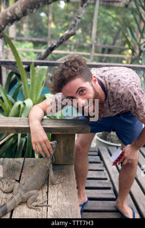 Man petting iguana Banque D'Images