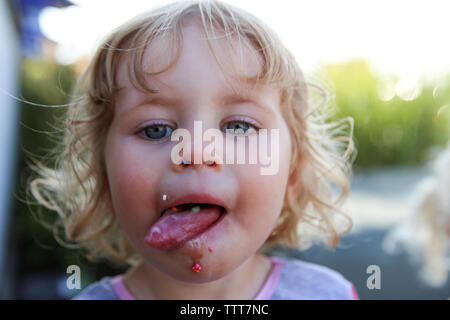 Close-up portrait of girl sticking out tongue Banque D'Images