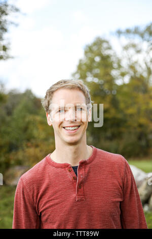 Portrait d'un homme debout et souriant à l'automne portant chemise décontractée Banque D'Images