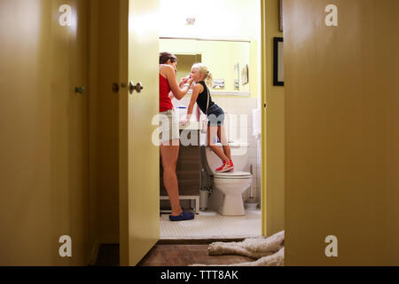 Aider maman fille brosser les dents dans la petite salle de bains dans la ville de new york Banque D'Images
