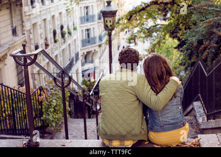 Vue arrière du couple sitting on steps in city Banque D'Images