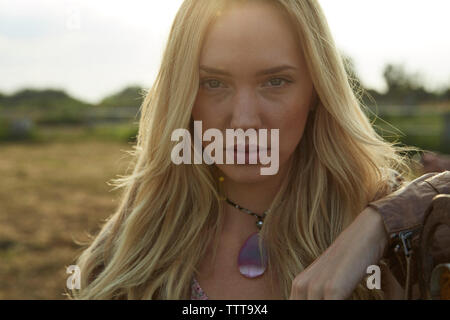 Portrait d'éleveur confiant contre sky in farm Banque D'Images