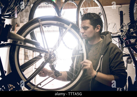 L'examen de la clientèle masculine des pneus de bicyclettes par store Banque D'Images