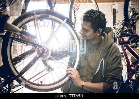L'examen de la clientèle masculine des pneus de bicyclettes en étant debout dans le magasin Banque D'Images