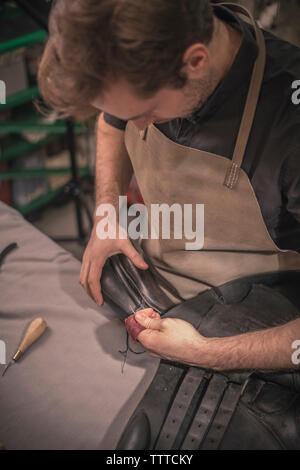 Cordonnier de fabrication des chaussures au poste de travail en atelier Banque D'Images