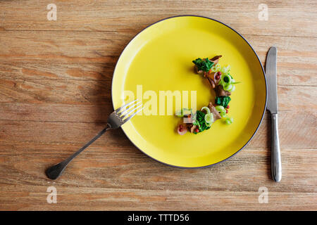 Vue de dessus de salade avec le couteau et la fourchette sur la table Banque D'Images