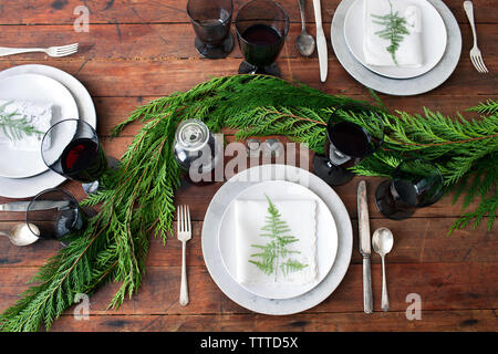 Vue de dessus de la vaisselle avec du vin rouge et des feuilles sur une table à manger Banque D'Images