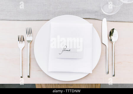 Vue de dessus de l'argenterie par plaque avec texte sur table à manger Banque D'Images