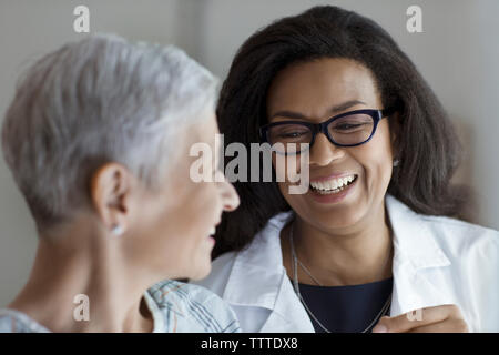 Happy doctor looking at female patient in hospital Banque D'Images