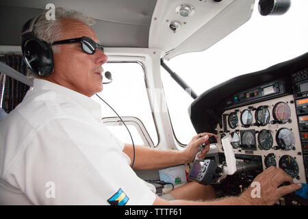 EXUMA, Bahamas. Le pilote aux commandes, l'hélice avion vers les îles Exuma. Banque D'Images