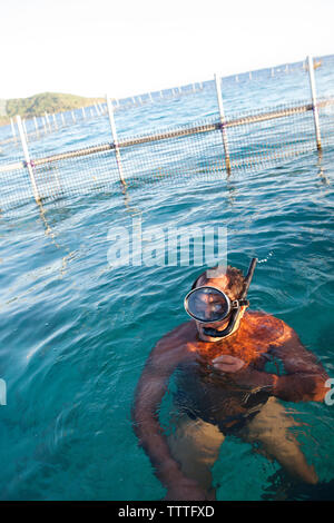 Polynésie Française, Île de Tahaa. Un pêcheur local dans son poisson le long de l'île de Tahaa. Banque D'Images