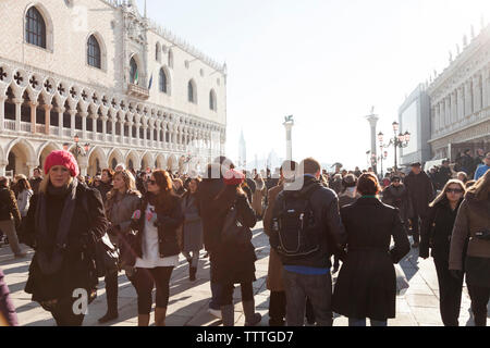 L'Italie, Venise. Une vue de la foule de la Place St Marc avec le palais des Doges sur la gauche et les colonnes du Lion et de San Teodoro, sur la droite. L Banque D'Images