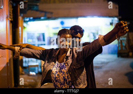 La JAMAÏQUE, Port Antonio. Un couple danse et qui pose pour un portrait dans le centre-ville de nuit. Banque D'Images