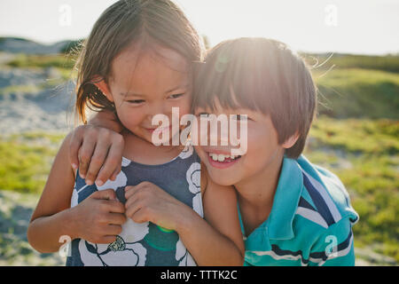 Happy brother avec sœur contre ciel sur sunny day Banque D'Images