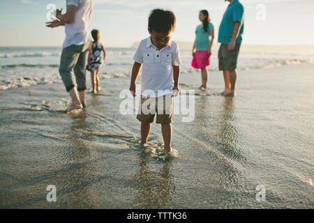 En famille pendant le coucher du soleil sur la mer Banque D'Images