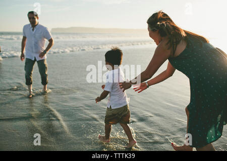 Heureux parents jouant avec son at beach Banque D'Images