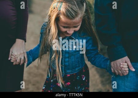 High angle view of parents and daughter's hands en marchant sur sentier Banque D'Images