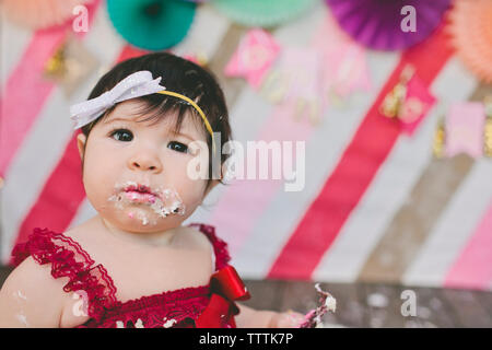 Portrait of cute baby girl with messy face au cours d'anniversaire Banque D'Images