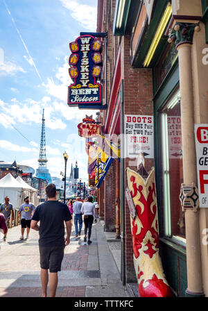 NFL fans marcher le long de Broadway passé gastropubs bars restaurants magasins de vêtements et bottes de cow-boy pendant NFLDraft 2019 Nashville, Tennessee. Banque D'Images