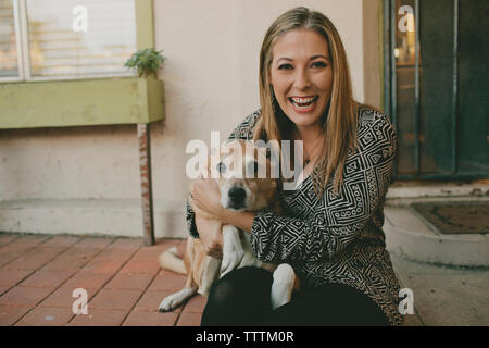 Portrait of cheerful woman with dog outdoors Banque D'Images