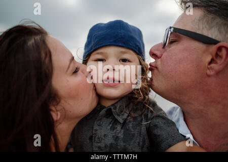 Portrait of cute fils avec les parents s'embrasser Banque D'Images