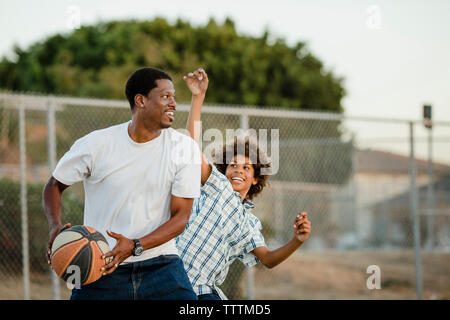 Heureux père jouant au basket-ball avec des fils à la cour Banque D'Images