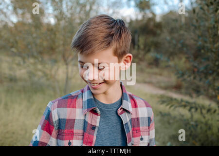 Close-up of boy standing on field at park Banque D'Images