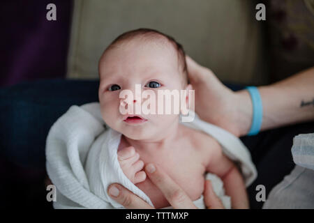 Au milieu de la mère avec son fils nouveau-né sitting on sofa at home Banque D'Images