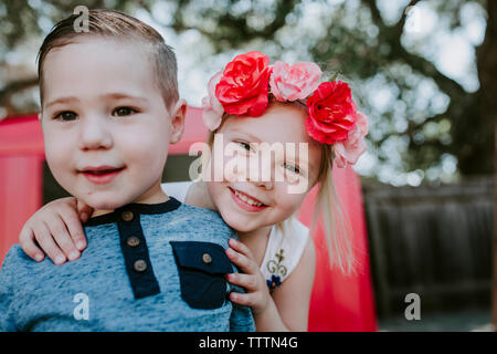 Portrait of cute smiling sœurs contre permanent dans une cour de garage rouge Banque D'Images