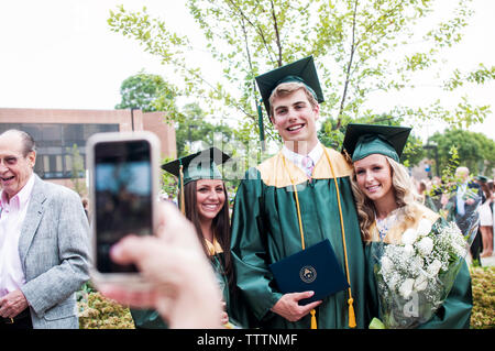 Portrait de personne photographiant des étudiants diplômés de cérémonie de remise de diplômes Banque D'Images