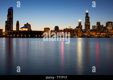 La ville illuminée par le lac Michigan contre ciel clair au crépuscule Banque D'Images