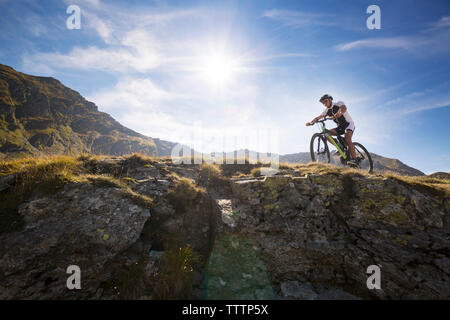 Low angle view of mountain biker riding bicycle against sky Banque D'Images