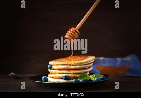 Délicieuses crêpes aux bleuets et au miel sur la table Banque D'Images