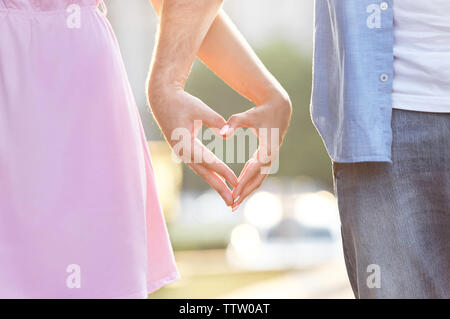 Young couple holding hands en forme de coeur Banque D'Images