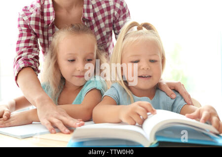 Mère avec ses filles à faire leurs devoirs Banque D'Images